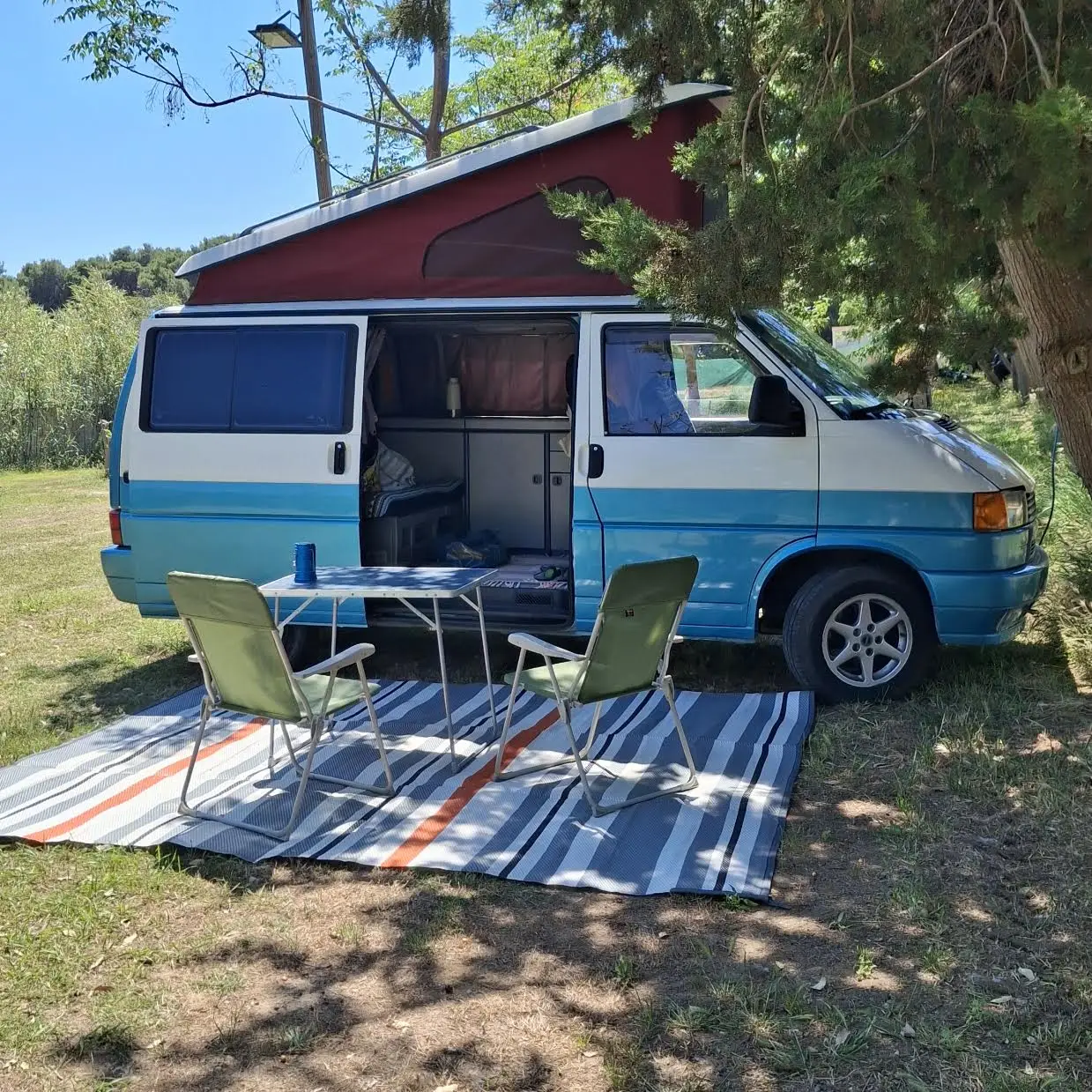 Van camperizzato vintage azzurro e bianco in campeggio